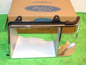 1981-1985 Ford Escort Mercury Lynx NOS LH HEAD LAMP DOOR BEZEL Chrome / Argent